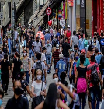 Comércio, pessoas caminham em rua movimentada no centro de São Paulo