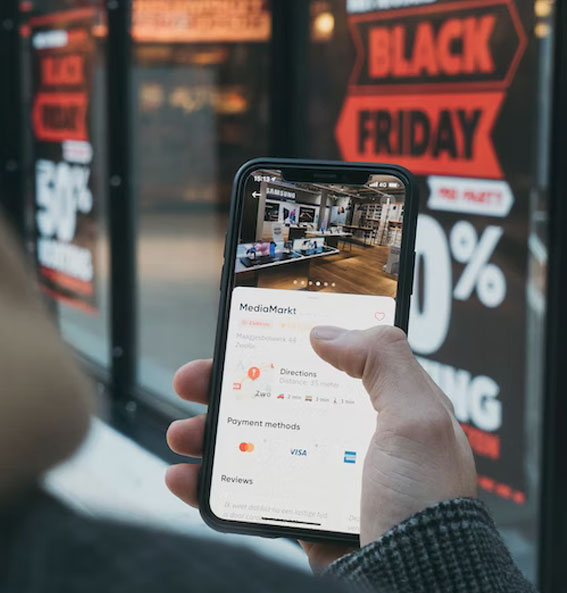 Consumidores interage com mobile em fente a loja durante Black Friday