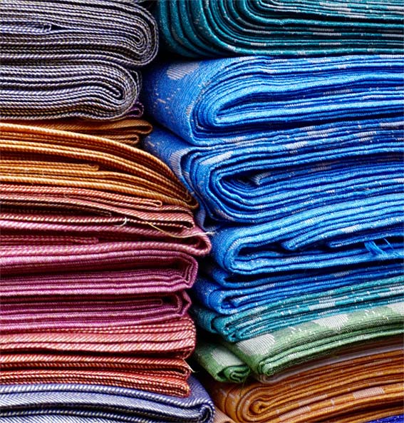 Pilha de tapetes, cores diversas. Téxtil. Téxteis. Foto: Pexels